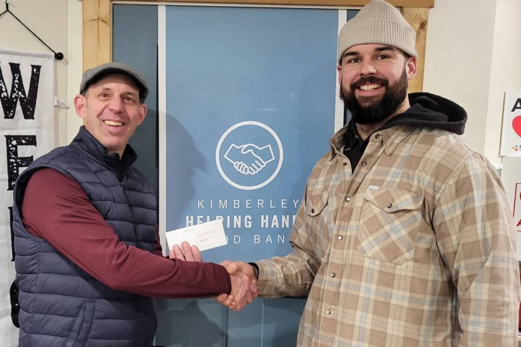 Backcut Barbershop owner Ethan Schnell (right) presents a donation of $1,659 to Kimberley Food Bank manager Thom Tarte. (Kimberley Food Bank/Submitted).