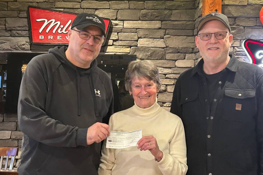 Carol Fergus, co-coordinator of the Kimberley Heritage Interpretive Panel Project, receives a $500 donation from Sullivan Pub owners Rob Van Baar (on left) and Aaron Lees (on right), towards the Interpretive Heritage panel project. (Submitted)